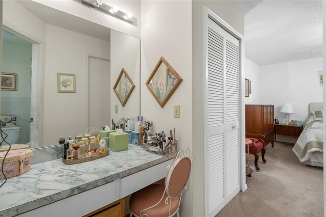 bathroom featuring a textured ceiling, vanity, and toilet