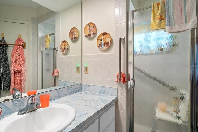 bathroom featuring tile walls, vanity, and an enclosed shower