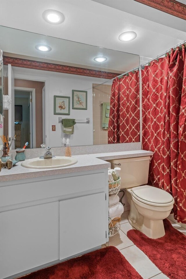 bathroom featuring tile patterned flooring, vanity, toilet, and curtained shower