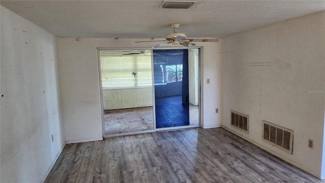 unfurnished dining area with ceiling fan, a textured ceiling, and hardwood / wood-style flooring