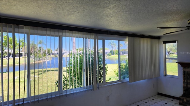 unfurnished sunroom with a water view, a healthy amount of sunlight, and ceiling fan