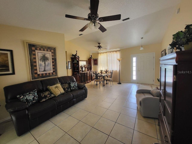 living room with vaulted ceiling, ceiling fan, and light tile patterned floors