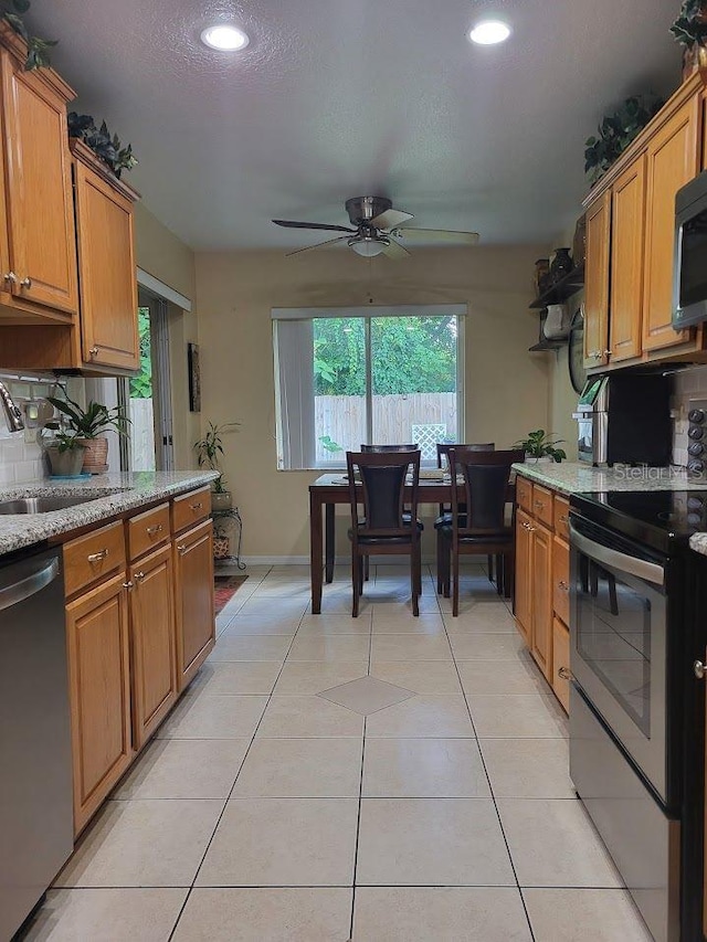 kitchen with decorative backsplash, ceiling fan, appliances with stainless steel finishes, and plenty of natural light