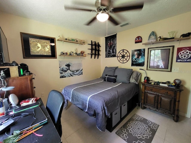 bedroom with ceiling fan, a textured ceiling, and light tile patterned flooring