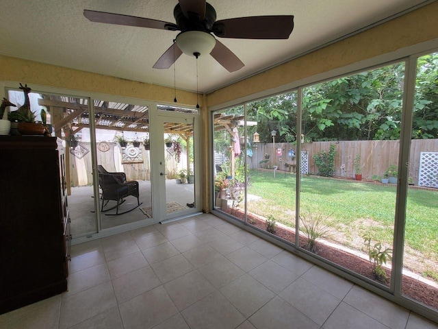 unfurnished sunroom featuring a wealth of natural light and ceiling fan