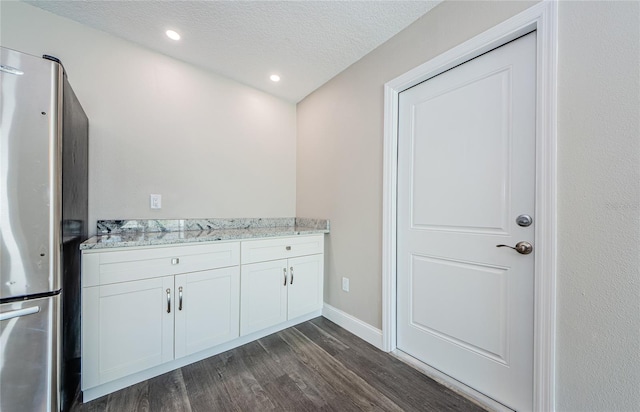 bathroom with wood-type flooring, vanity, and a textured ceiling