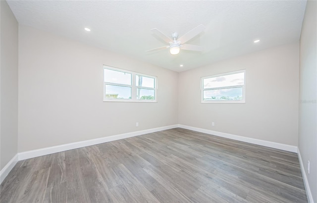 empty room with ceiling fan, hardwood / wood-style flooring, and a textured ceiling