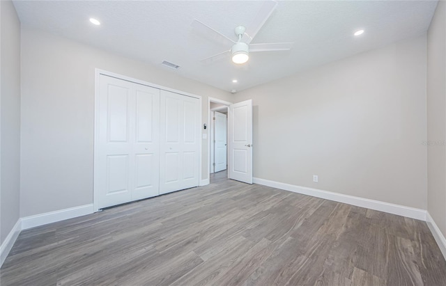 unfurnished bedroom featuring ceiling fan, wood-type flooring, a closet, and a textured ceiling