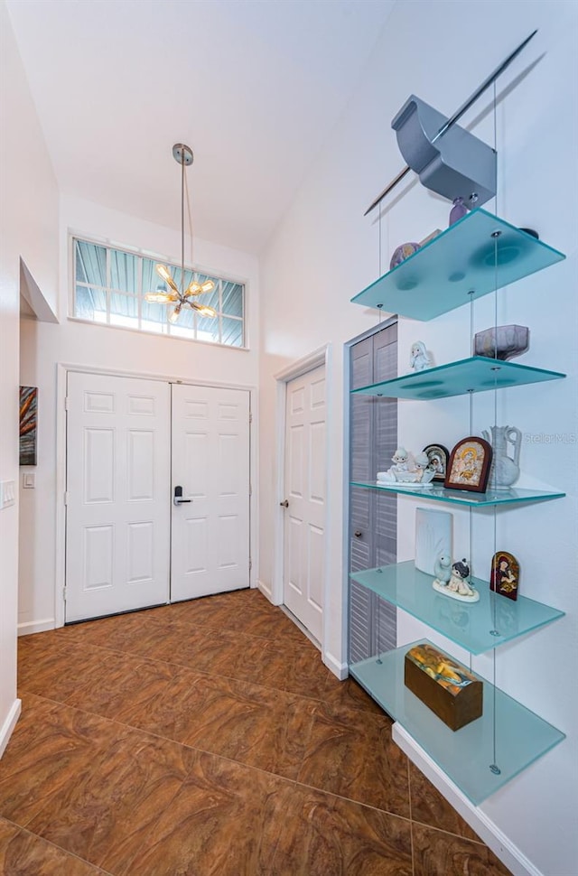 foyer entrance featuring high vaulted ceiling and an inviting chandelier