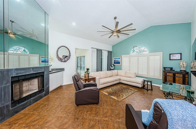 tiled living room featuring a textured ceiling, high vaulted ceiling, and a tiled fireplace