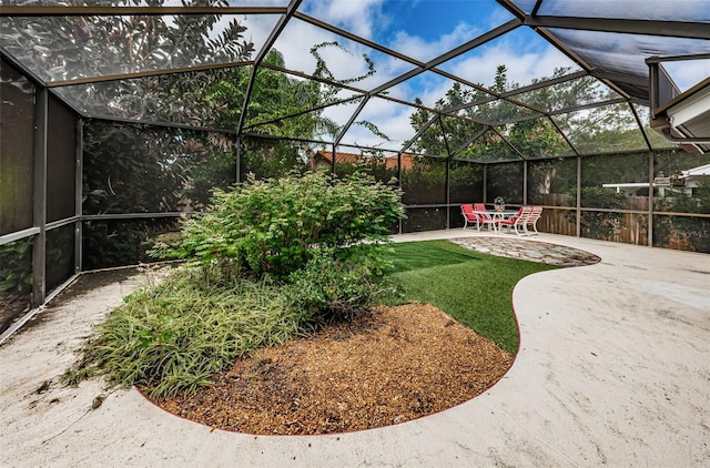 view of yard with glass enclosure and a patio area