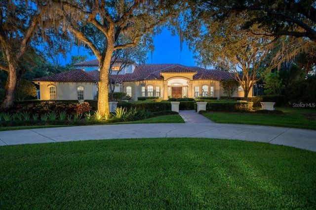 mediterranean / spanish house with a front yard