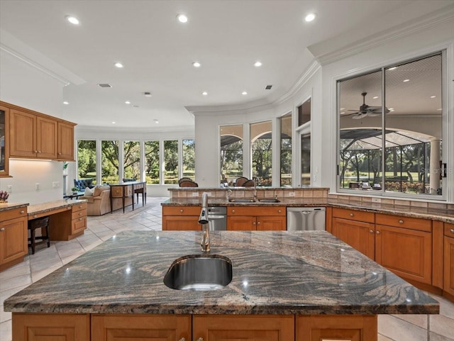 kitchen featuring stainless steel dishwasher, ceiling fan, a spacious island, and dark stone countertops