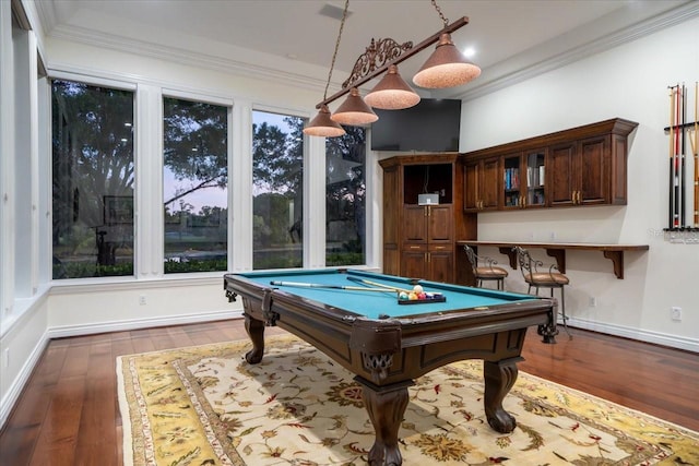 rec room featuring dark hardwood / wood-style flooring, a wealth of natural light, ornamental molding, billiards, and bar