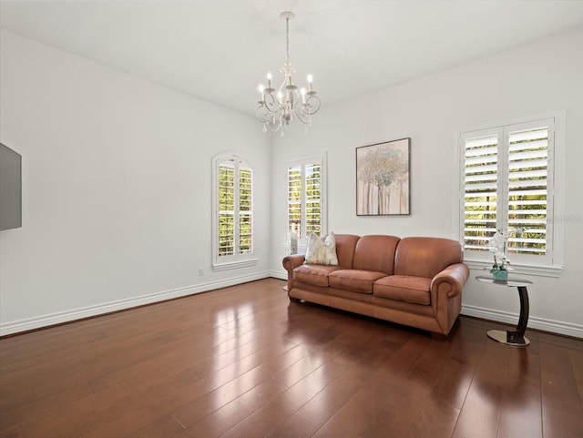 living room with dark wood-type flooring and a notable chandelier