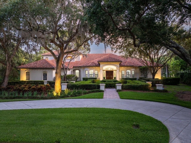 mediterranean / spanish-style home featuring a lawn