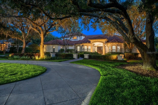 mediterranean / spanish-style house with a front yard