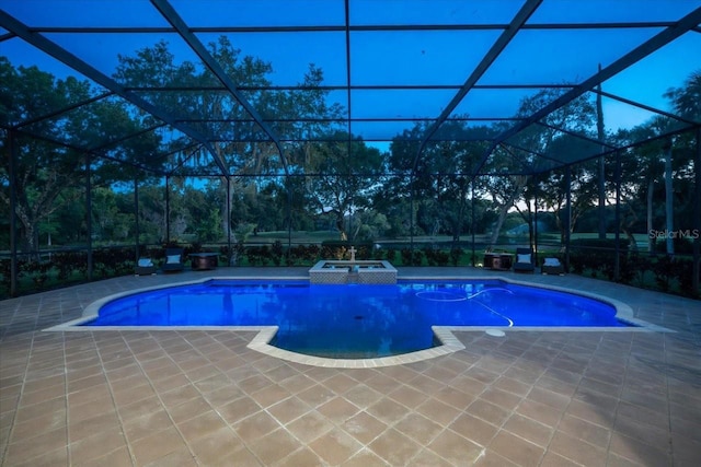 view of swimming pool featuring glass enclosure, an in ground hot tub, and a patio