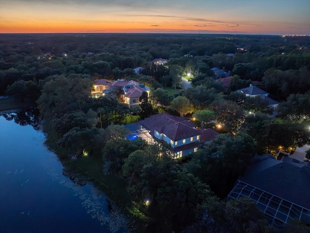 aerial view at dusk featuring a water view