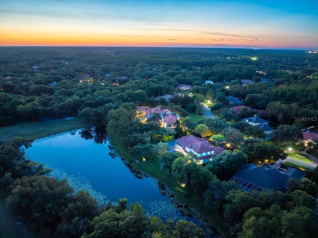 aerial view at dusk featuring a water view