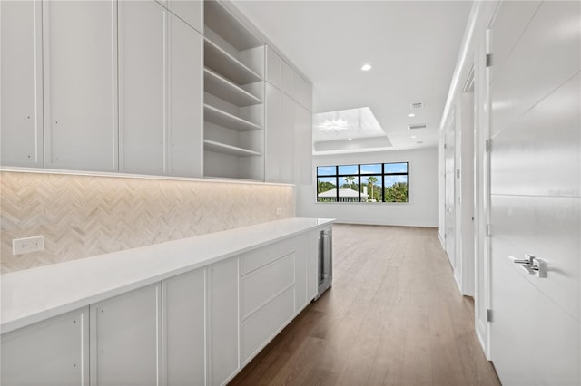 hallway featuring wood finished floors, visible vents, and recessed lighting