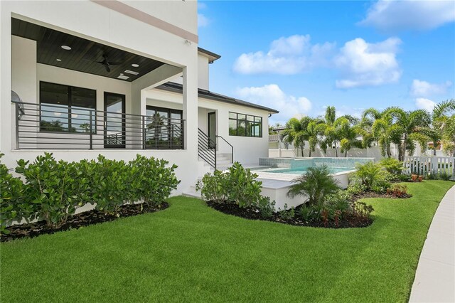 view of yard featuring ceiling fan, fence, and a fenced in pool