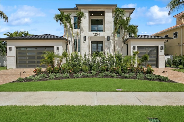 view of front of home with a garage and a front lawn