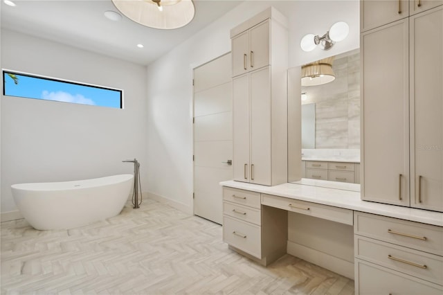 full bathroom featuring recessed lighting, a freestanding bath, vanity, and baseboards