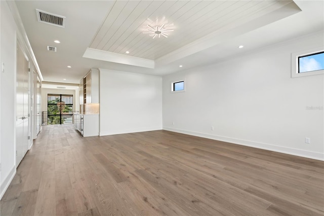 unfurnished room with hardwood / wood-style flooring, a raised ceiling, crown molding, and wooden ceiling