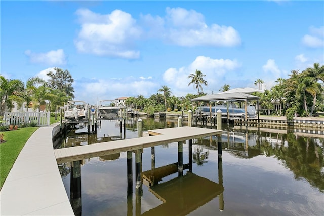 view of dock with a water view, boat lift, and fence