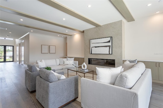 living room featuring hardwood / wood-style flooring, beamed ceiling, and a premium fireplace