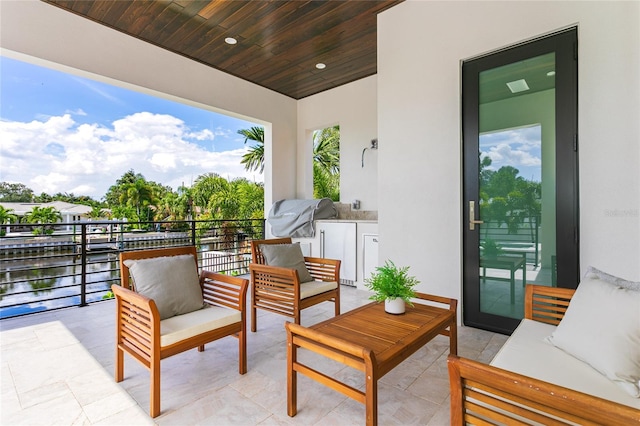 view of patio featuring a balcony, grilling area, and a water view