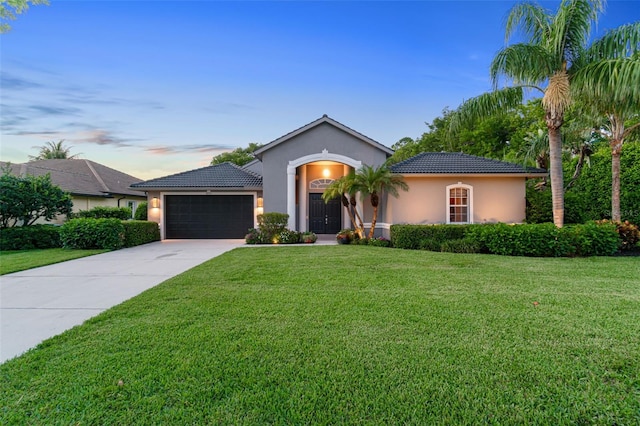 view of front of home with a garage and a yard