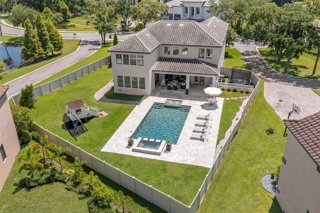 back of house with a fenced in pool, outdoor lounge area, a lawn, and a patio