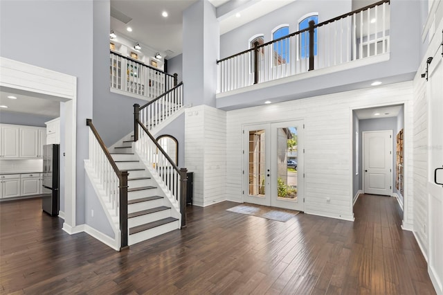 foyer entrance with dark hardwood / wood-style flooring, french doors, and a towering ceiling