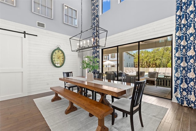 dining area featuring a barn door and dark wood-type flooring