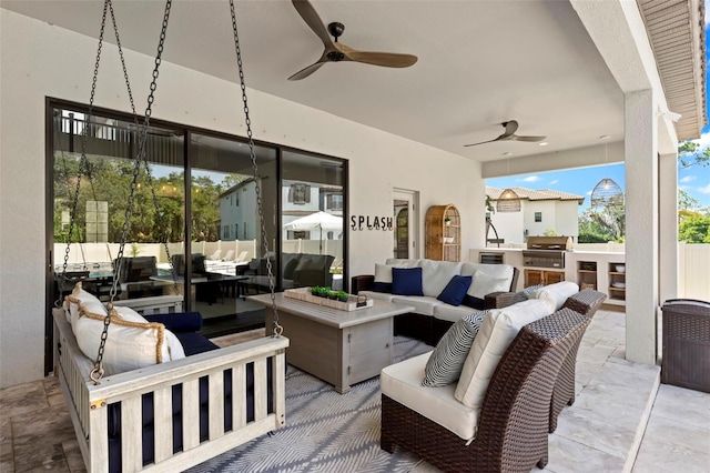 view of patio featuring area for grilling, an outdoor living space, ceiling fan, and an outdoor kitchen