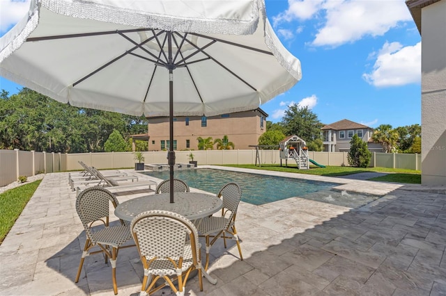 view of swimming pool featuring a playground and a patio