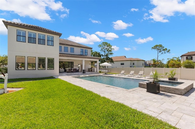 view of pool with an in ground hot tub, a yard, a patio, and an outdoor hangout area