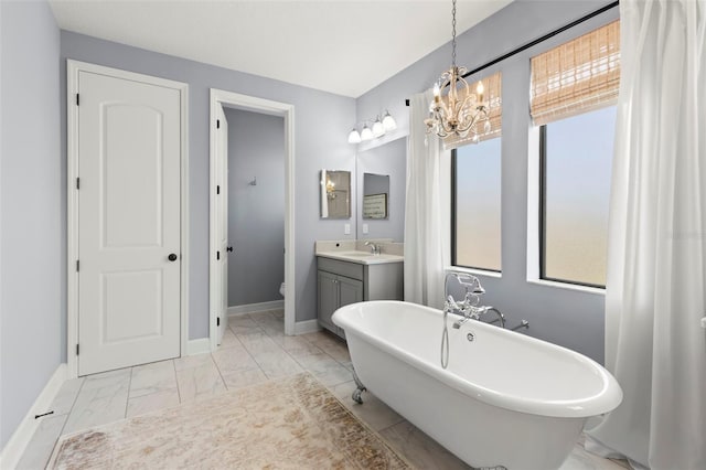 bathroom featuring a bathtub, vanity, a chandelier, and toilet