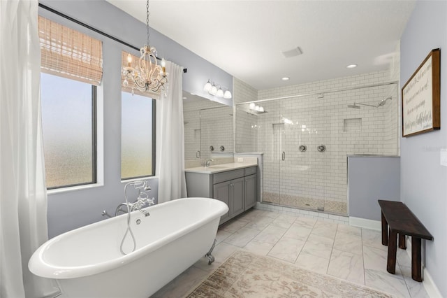 bathroom featuring vanity, independent shower and bath, and an inviting chandelier