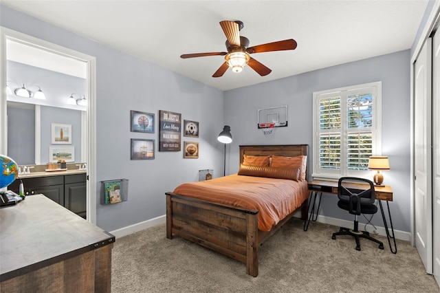 bedroom featuring ceiling fan, a closet, light carpet, and ensuite bath