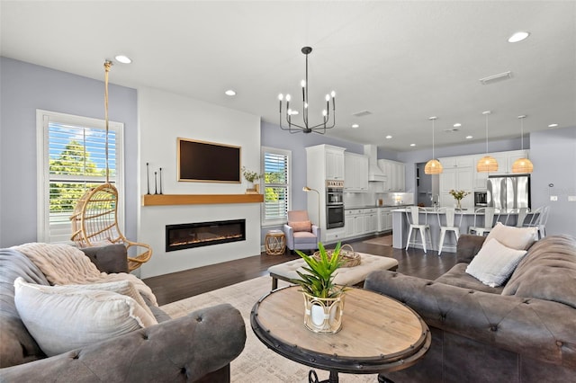 living room with a chandelier and dark hardwood / wood-style flooring