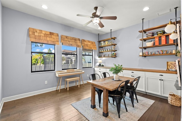 dining area featuring ceiling fan, dark hardwood / wood-style flooring, and indoor bar