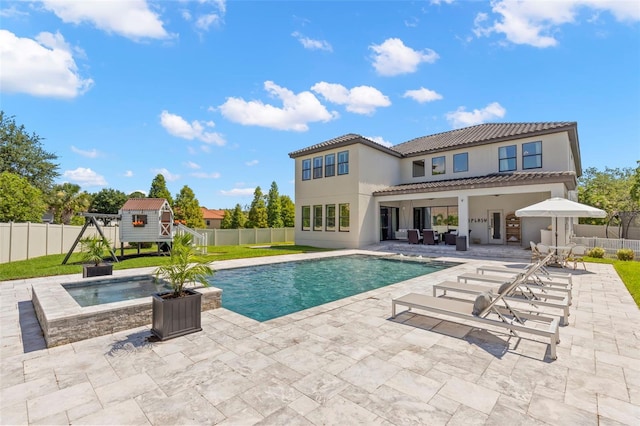 view of swimming pool featuring an in ground hot tub, a patio, and a storage shed