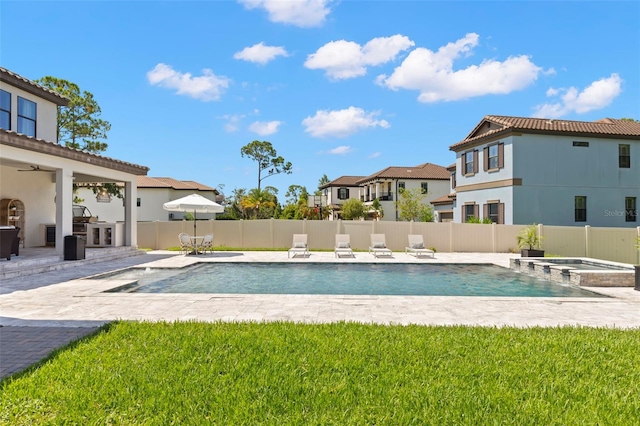 view of swimming pool featuring an in ground hot tub, a patio, and an outdoor kitchen