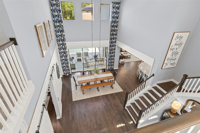 staircase with a high ceiling and hardwood / wood-style flooring