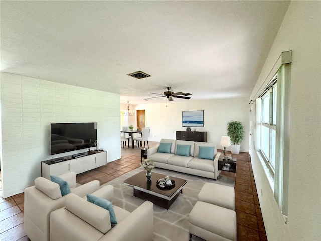 living room featuring a textured ceiling and ceiling fan