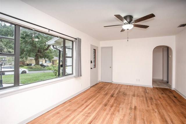 empty room with ceiling fan and light hardwood / wood-style floors