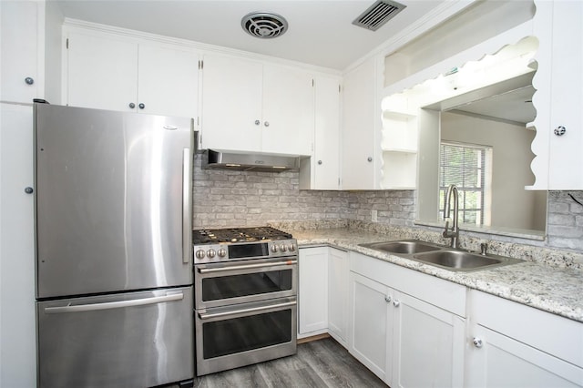 kitchen featuring sink, wall chimney range hood, appliances with stainless steel finishes, and white cabinets